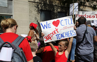 Courtney Sinisi (cq), left, stands next to her daughter Mia, 7, while the second grader holds up a sign in support of the Chicago Teachers Union at the CTU "strike headquarters" outside Teamster City Local 705 in Chicago on Saturday, Sept. 8, 2012. Teachers, paraprofessionals, school clinicians, parents and supporters picked up picket signs and other strike materials. Members of the CTU plan to strike Monday if contract negotiations fail. (Keri Wiginton/Chicago Tribune) B582362464Z.1 ....OUTSIDE TRIBUNE CO.- NO MAGS, NO SALES, NO INTERNET, NO TV, CHICAGO OUT, NO DIGITAL MANIPULATION...